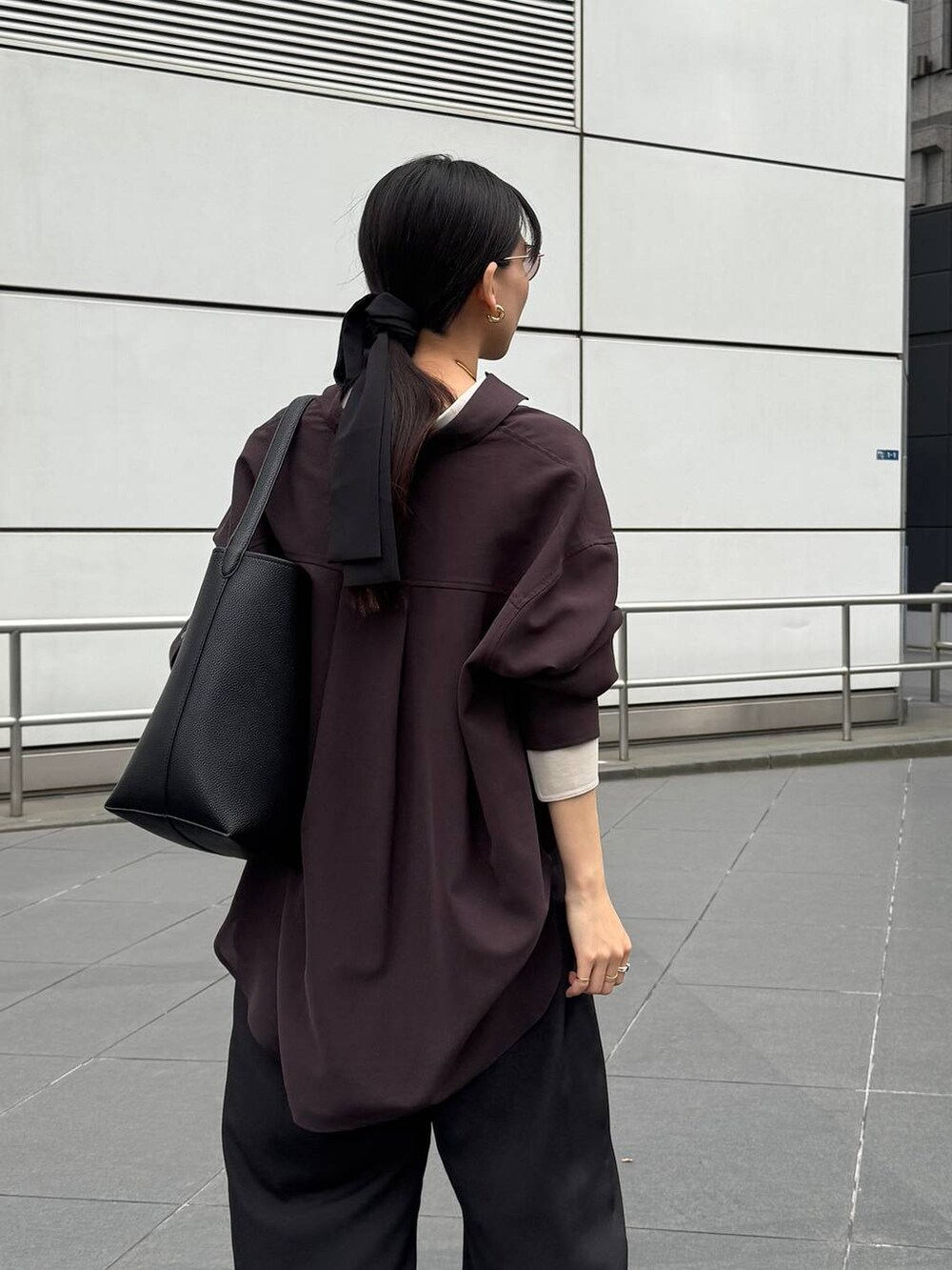 ブラック系のパンプス、ブラック系のトートバッグ、ブラウン系のシャツ/ブラウスを着用したレディースの夏コーディネートの5枚目の写真