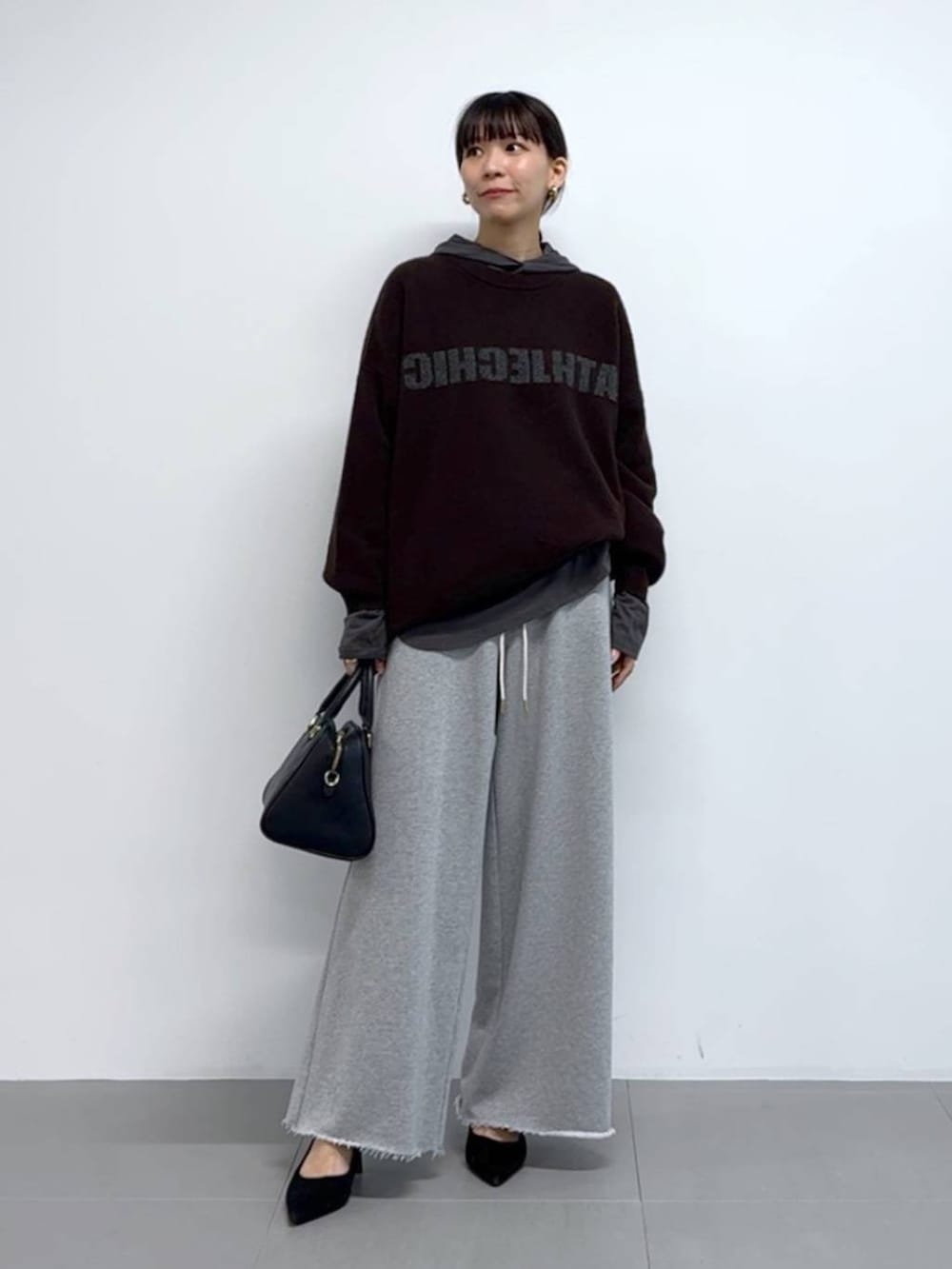 グレー系のTシャツ/カットソー、ブラック系のボストンバッグ、ブラック系のパンプスを着用したレディースの秋コーディネートの5枚目の写真