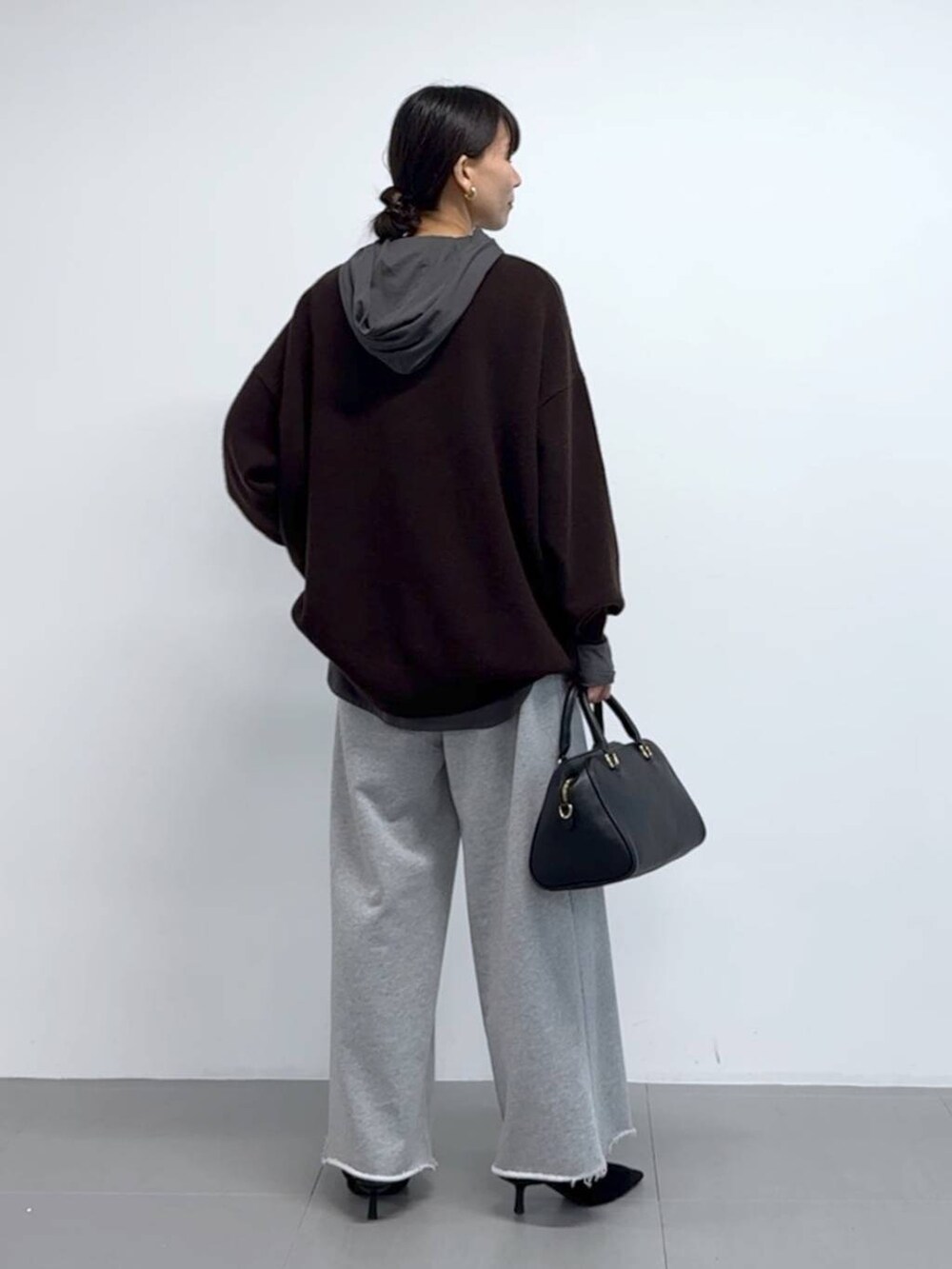 グレー系のTシャツ/カットソー、ブラック系のボストンバッグ、ブラック系のパンプスを着用したレディースの秋コーディネートの4枚目の写真