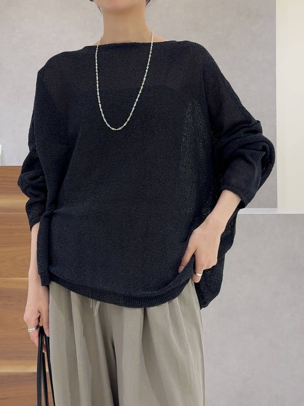 ブラック系のニット/セーター、ブラック系のトートバッグ、ブラック系のキャミソールを着用したレディースの夏コーディネートの6枚目の写真