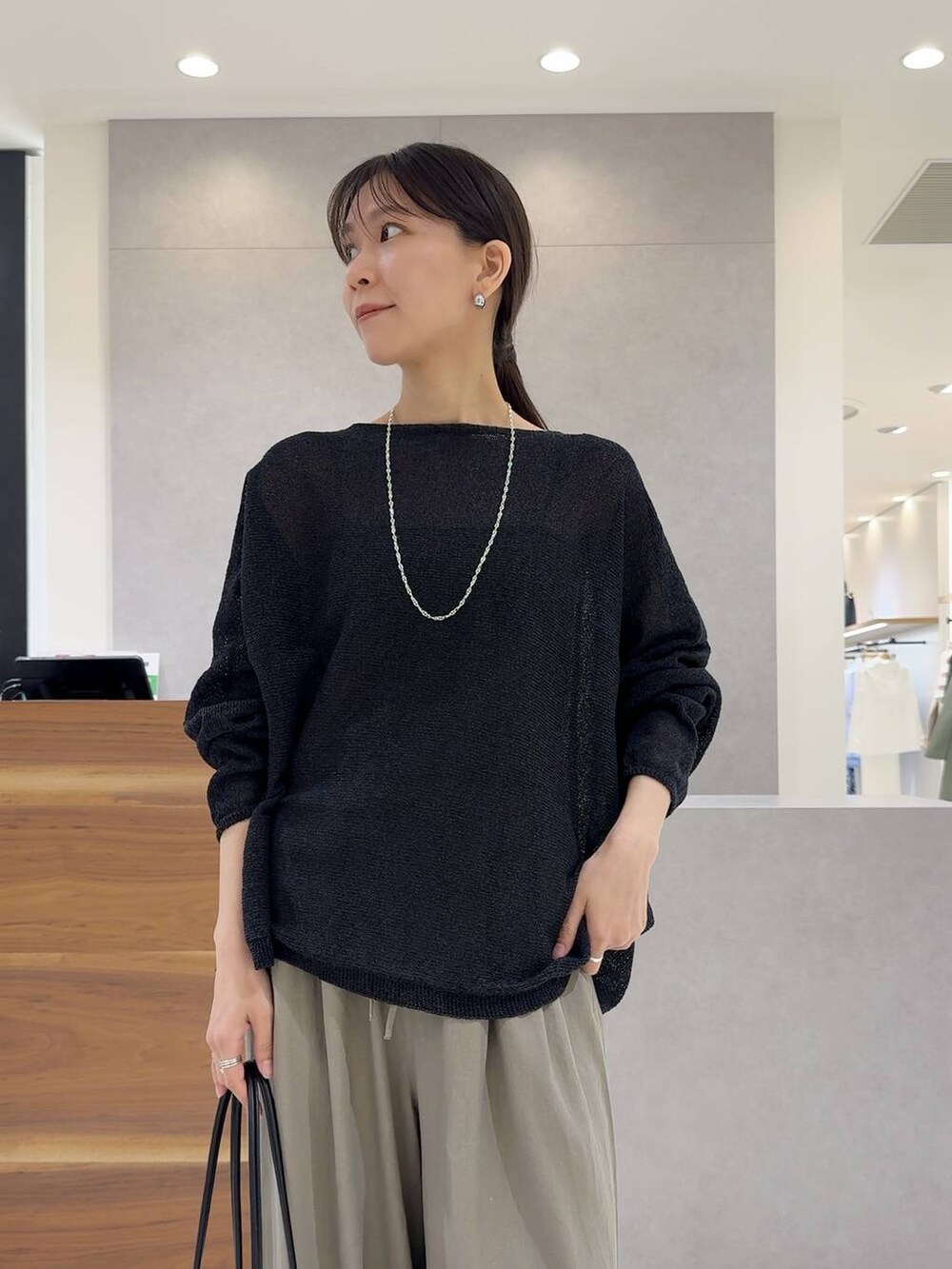 ブラック系のニット/セーター、ブラック系のトートバッグ、ブラック系のキャミソールを着用したレディースの夏コーディネートの5枚目の写真