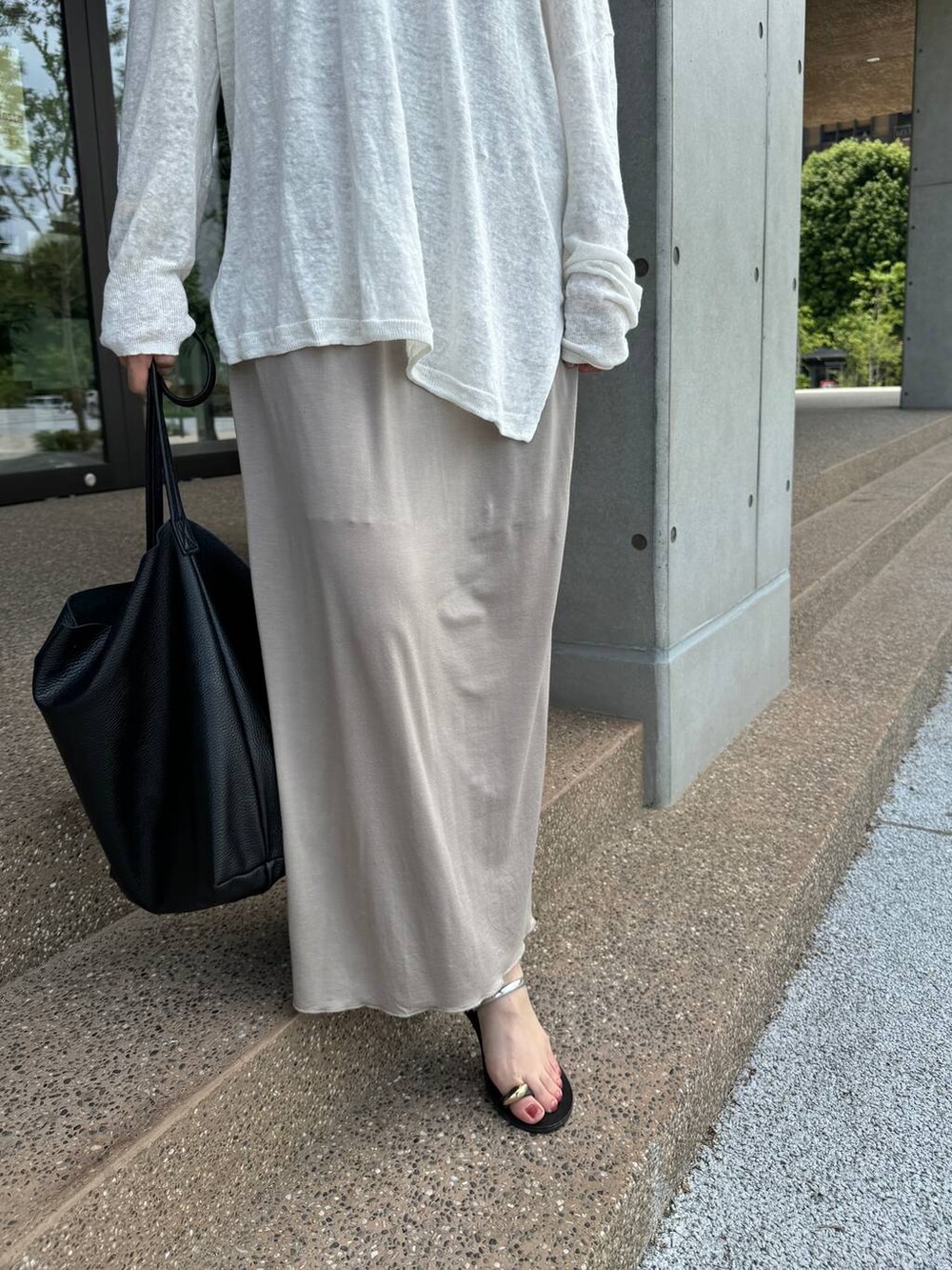 ホワイト系のニット/セーター、ベージュ系のスカート、ベージュ系のタンクトップを着用したレディースの夏コーディネートの8枚目の写真