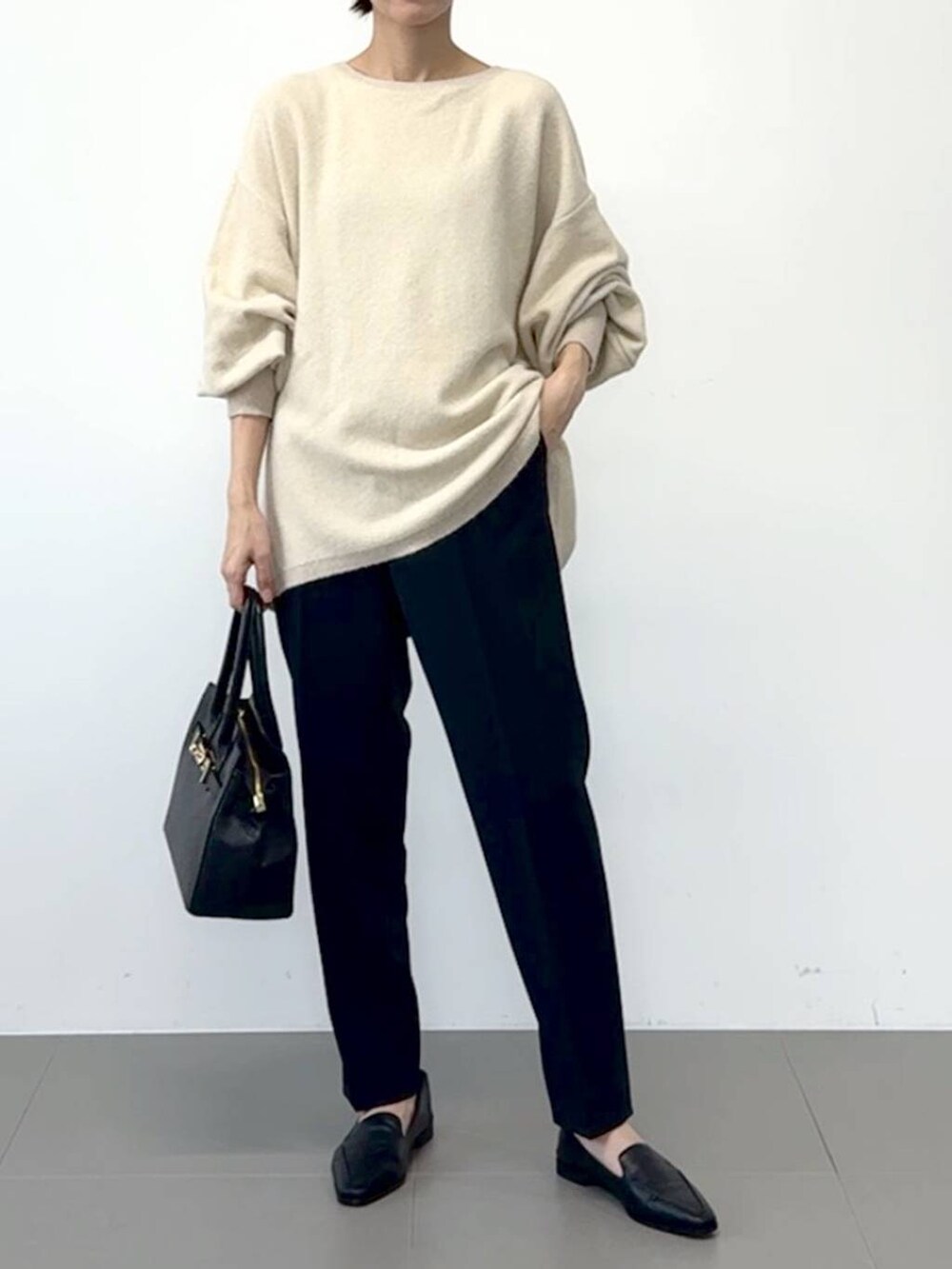 ブラック系のローファー、ブラック系のスラックス、ホワイト系のニット/セーターを着用したレディースの冬コーディネートの3枚目の写真