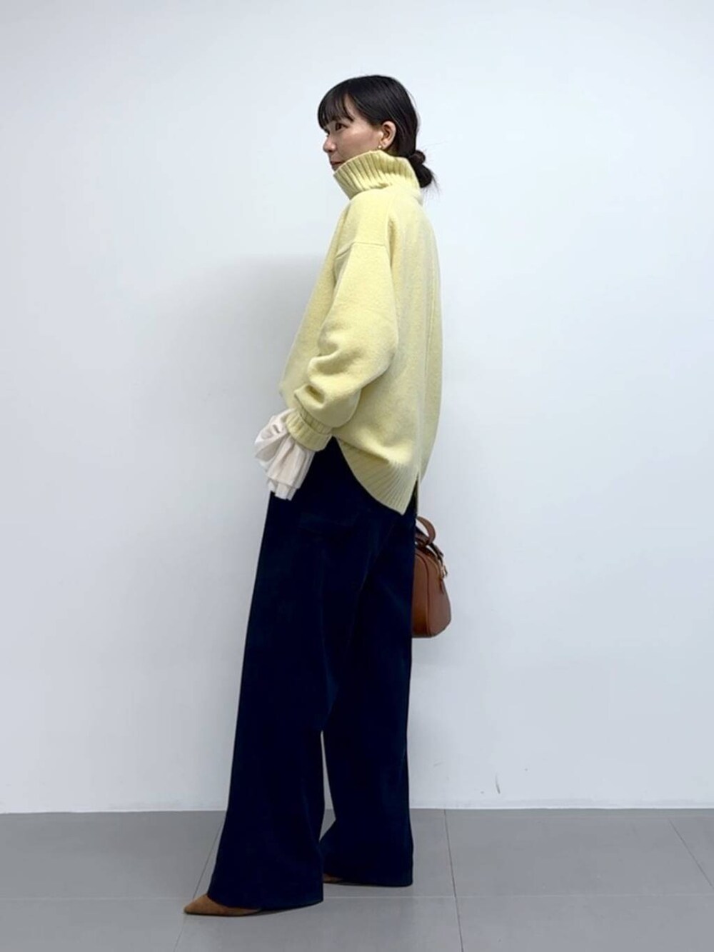 ブルー系のその他パンツ、イエロー系のボストンバッグ、ブラウン系のパンプスを着用したレディースの秋コーディネートの2枚目の写真