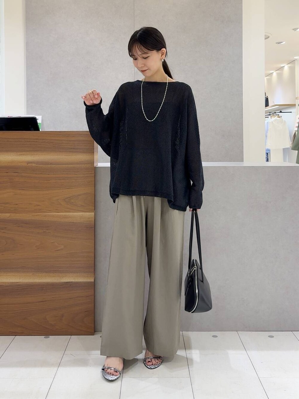 ブラック系のニット/セーター、ブラック系のトートバッグ、ブラック系のキャミソールを着用したレディースの夏コーディネートの7枚目の写真