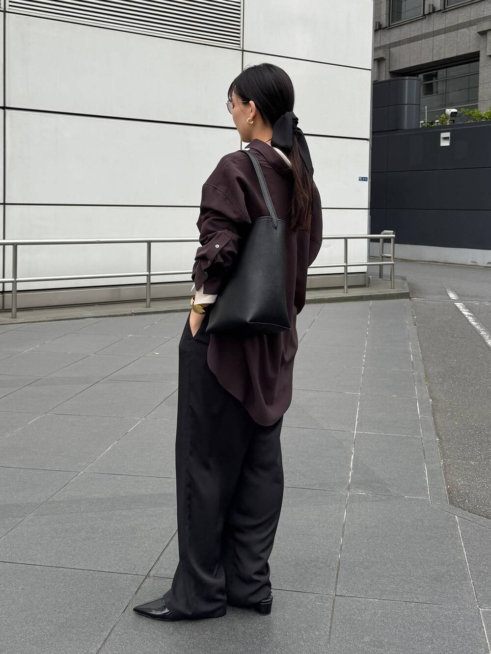 ブラック系のパンプス、ブラック系のトートバッグ、ブラウン系のシャツ/ブラウスを着用したレディースの夏コーディネートの3枚目の写真