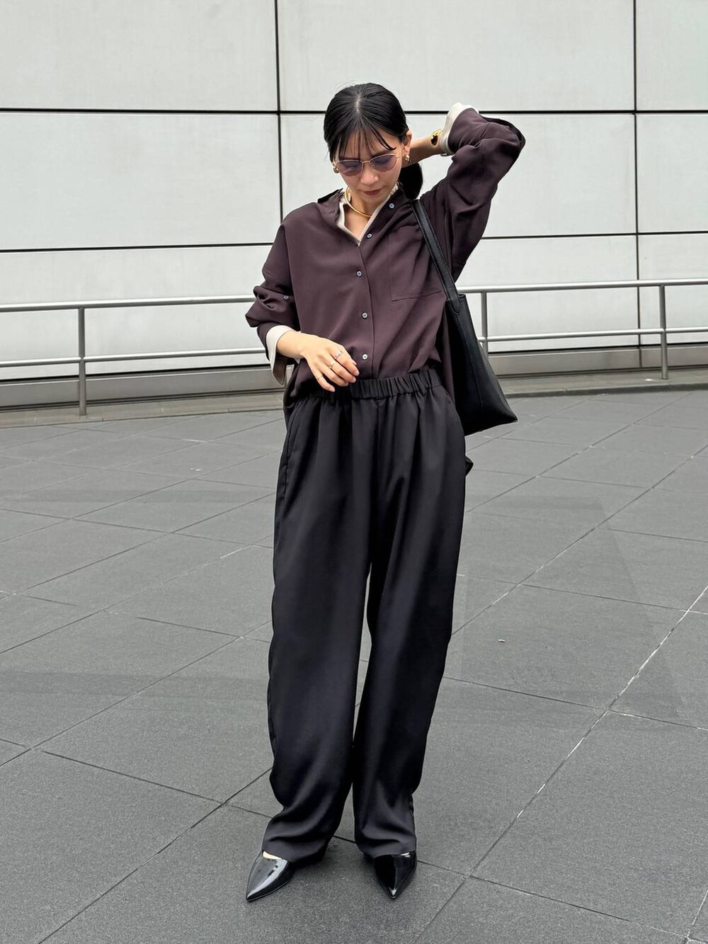 ブラック系のパンプス、ブラック系のトートバッグ、ブラウン系のシャツ/ブラウスを着用したレディースの夏コーディネートの6枚目の写真