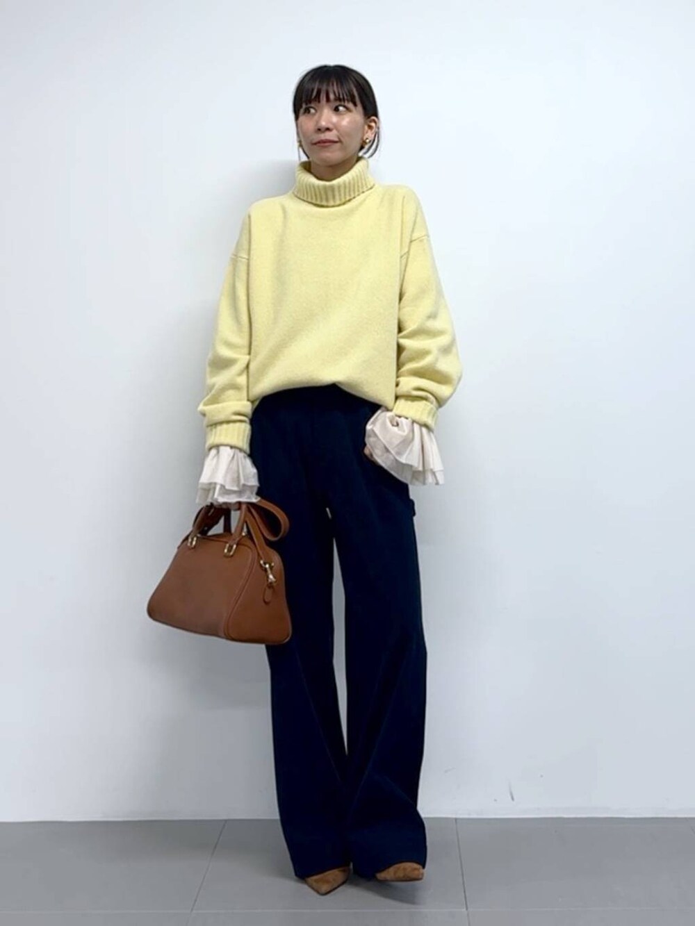 ブルー系のその他パンツ、イエロー系のボストンバッグ、ブラウン系のパンプスを着用したレディースの秋コーディネートの4枚目の写真