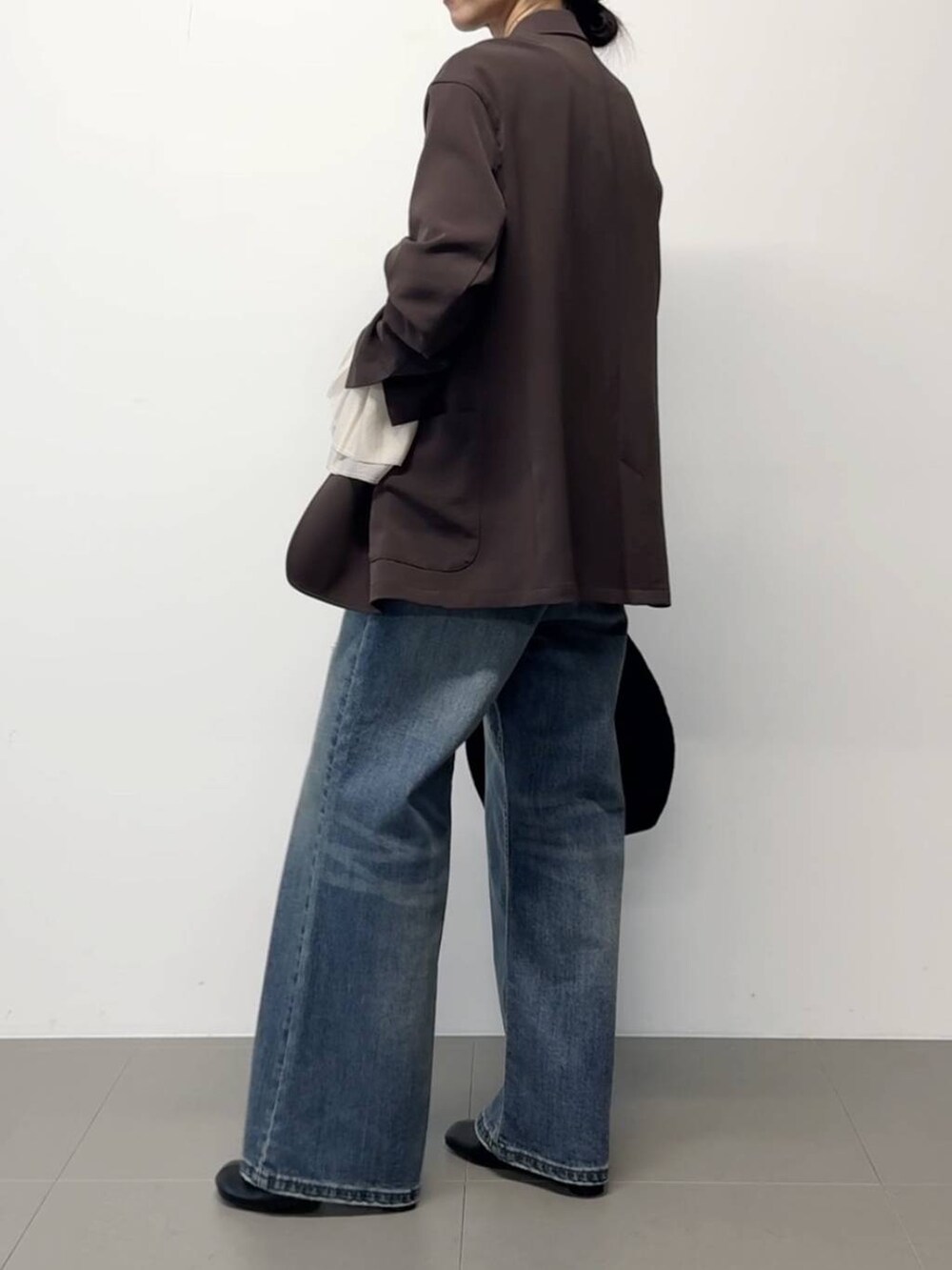 ブラウン系のテーラードジャケット、ブラック系のトートバッグ、その他のチョーカーを着用したレディースの秋コーディネートの3枚目の写真