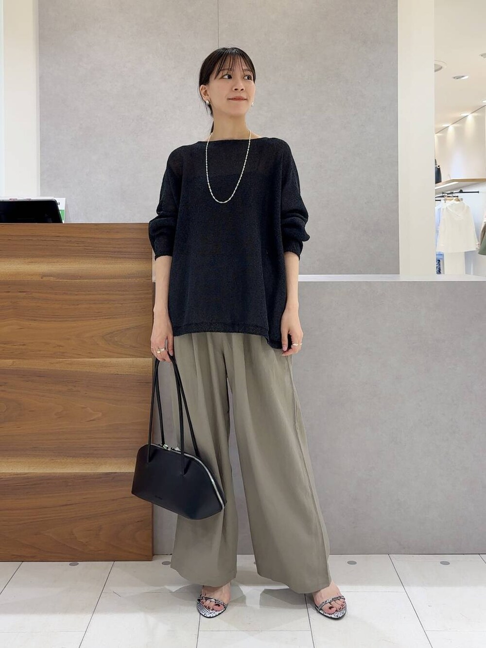 ブラック系のニット/セーター、ブラック系のトートバッグ、ブラック系のキャミソールを着用したレディースの夏コーディネートの9枚目の写真