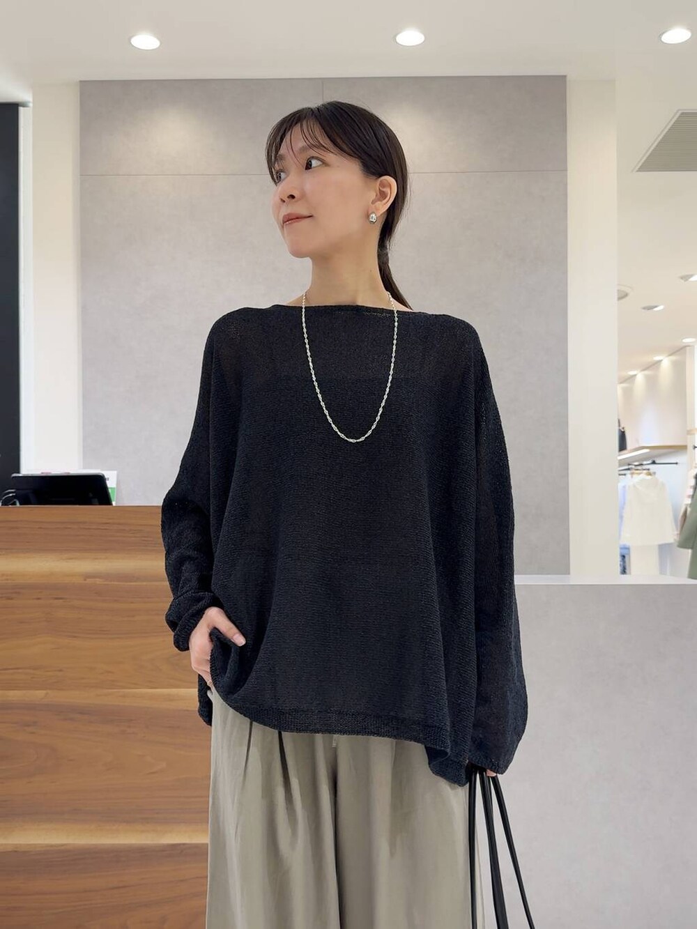 ブラック系のニット/セーター、ブラック系のトートバッグ、ブラック系のキャミソールを着用したレディースの夏コーディネートの8枚目の写真