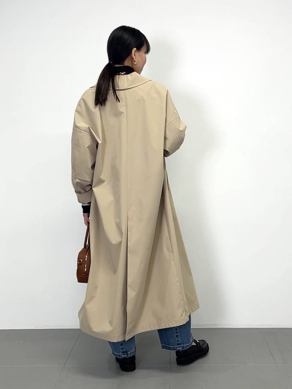 ブラック系のローファー、ブラック系のニット/セーター、ブラウン系のハンドバッグを着用したレディースの冬コーディネートの7枚目の写真