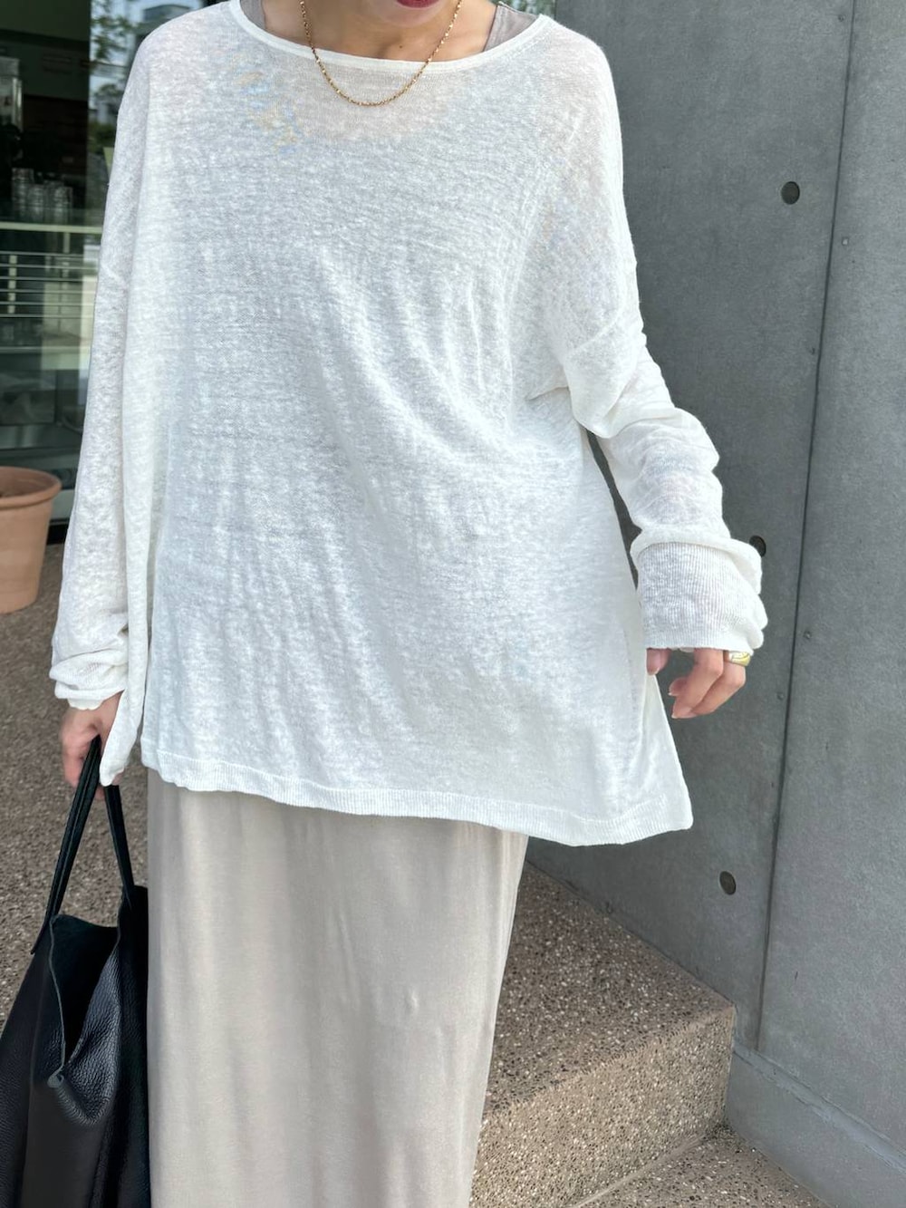 ホワイト系のニット/セーター、ベージュ系のスカート、ベージュ系のタンクトップを着用したレディースの夏コーディネートの4枚目の写真