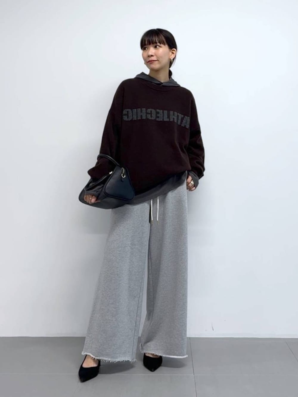 グレー系のTシャツ/カットソー、ブラック系のボストンバッグ、ブラック系のパンプスを着用したレディースの秋コーディネートの2枚目の写真