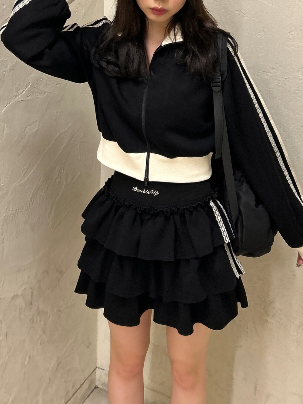 ブラック系のスウェット、ブラック系のスカート、ホワイト系のスニーカーを着用したレディースの秋コーディネートの4枚目の写真