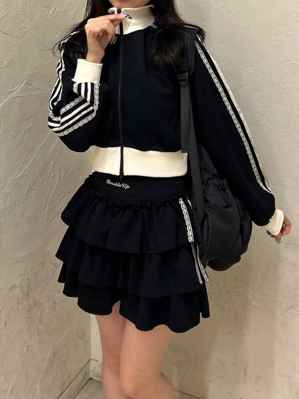 ブラック系のスウェット、ブラック系のスカート、ホワイト系のスニーカーを着用したレディースの秋コーディネートの3枚目の写真