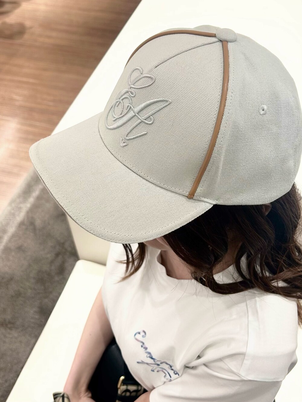 ホワイト系のTシャツ/カットソー、ブラック系のショルダーバッグ、グレー系のキャップを着用したレディースの春コーディネートの4枚目の写真