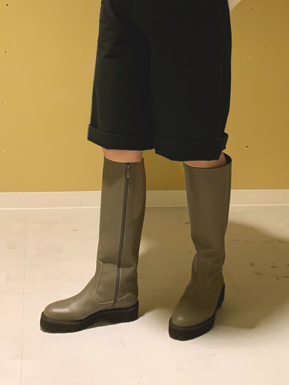 グリーン系のブーツを着用したレディースの秋コーディネートの2枚目の写真