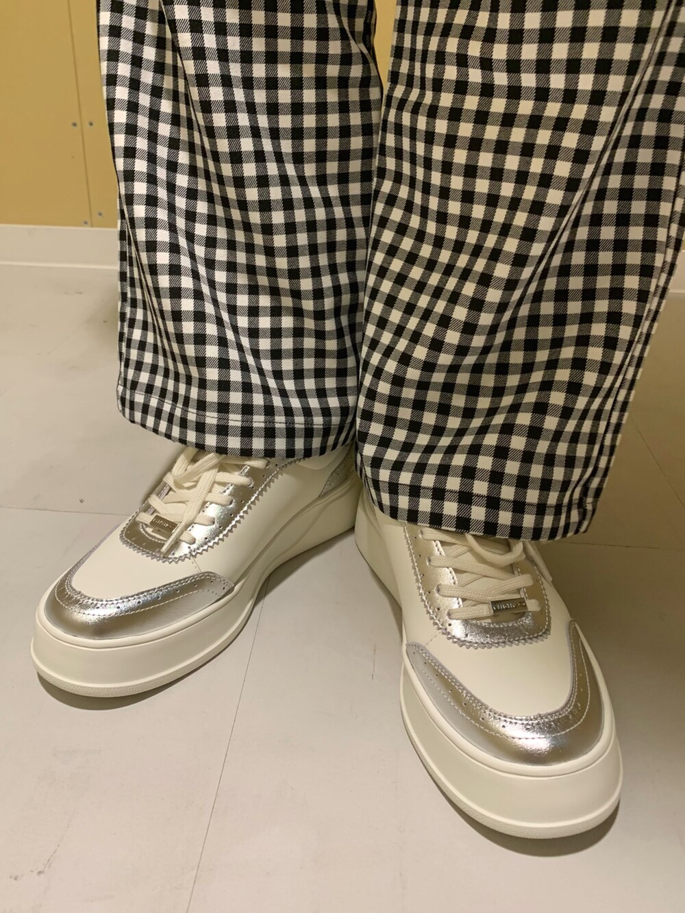 シルバー系のスニーカーを着用したレディースの春コーディネートの2枚目の写真