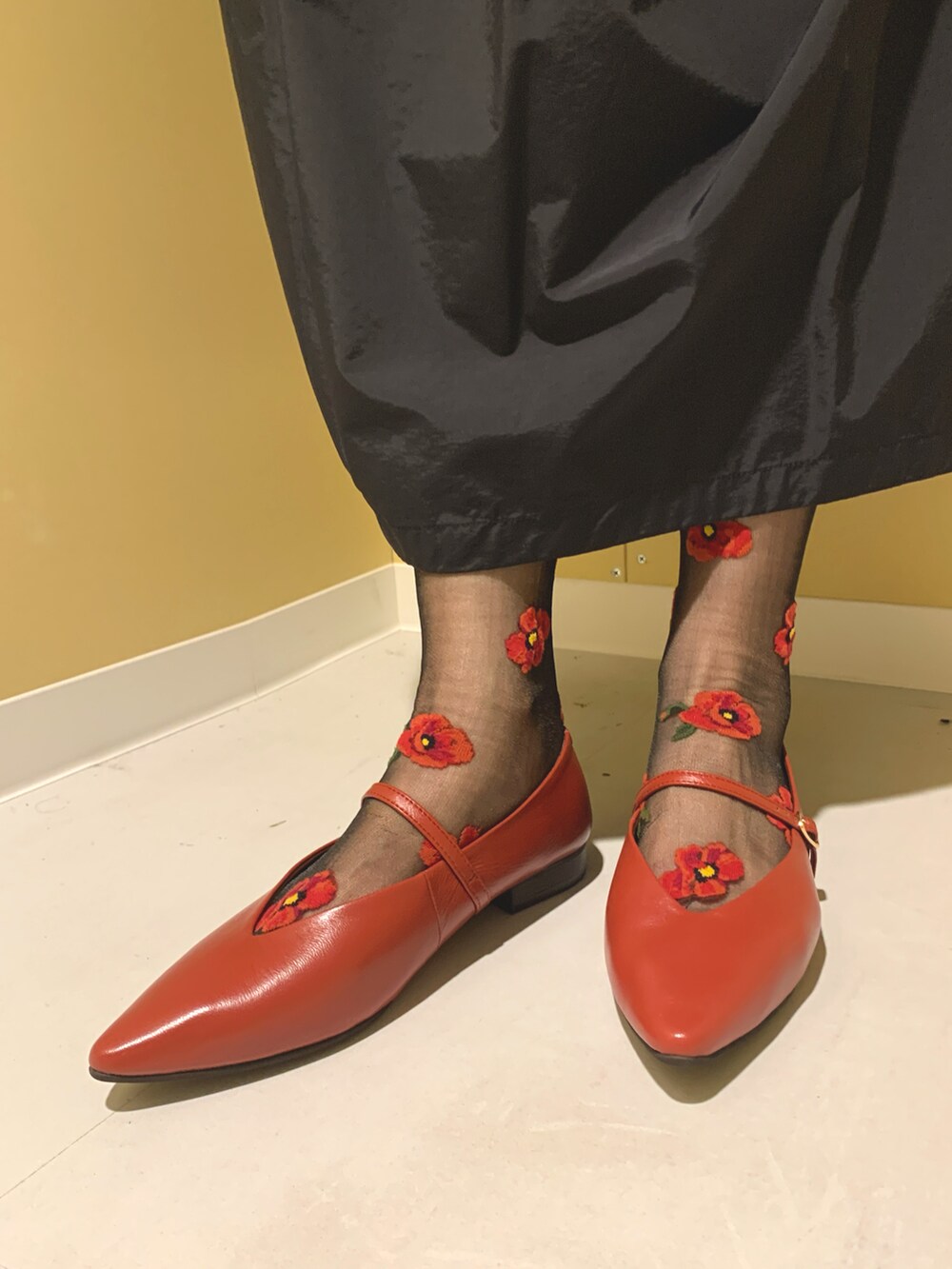 レッド系のパンプスを着用したレディースの秋コーディネートの2枚目の写真