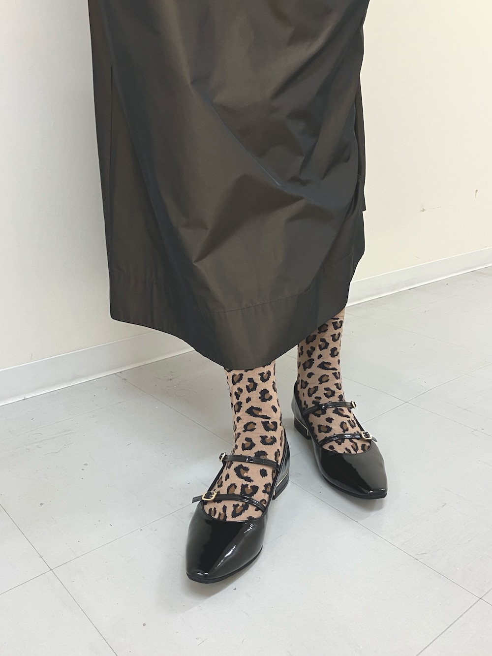 ブラック系のパンプスを着用したレディースの秋コーディネートの2枚目の写真