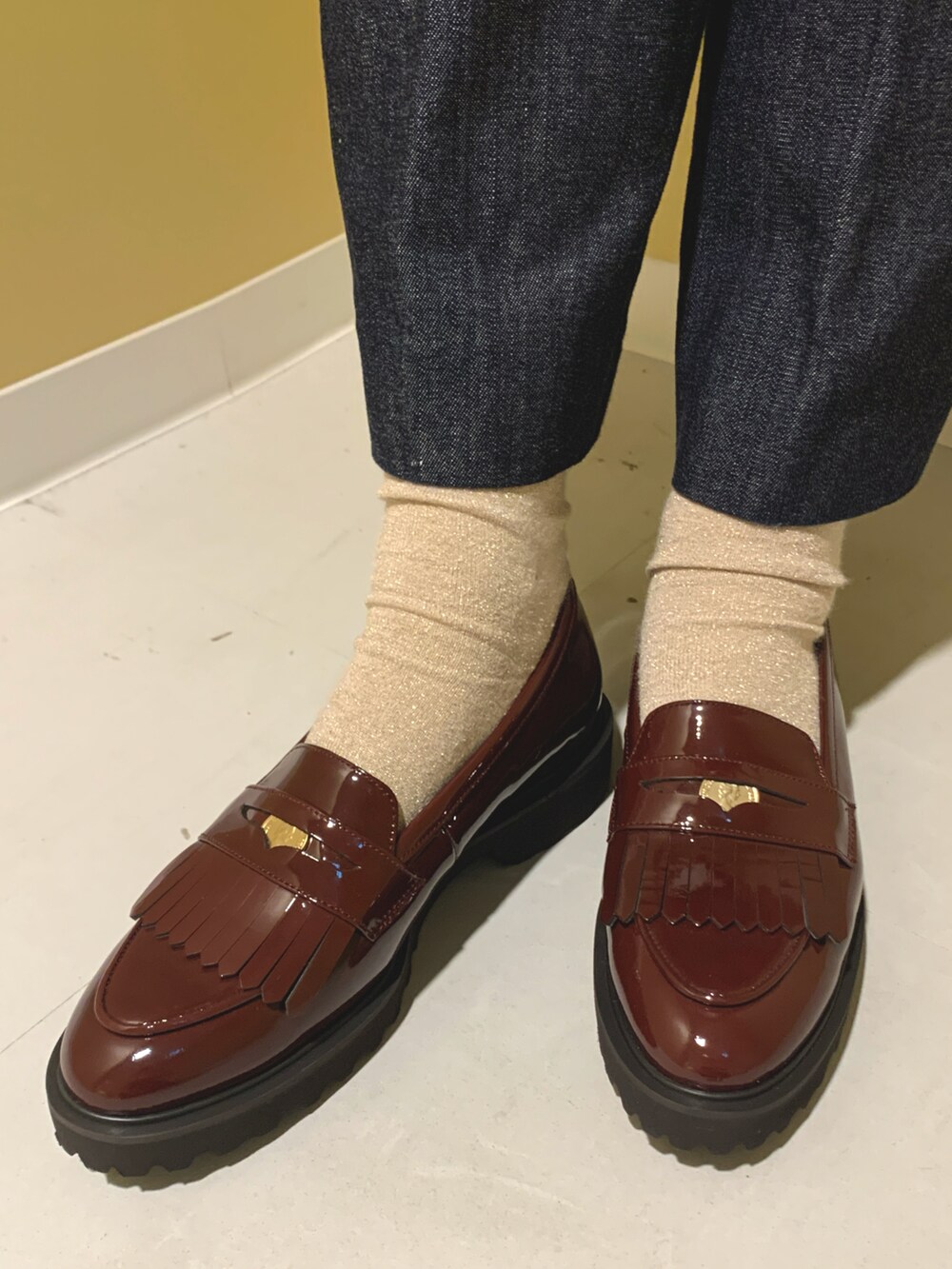 レッド系のローファーを着用したレディースの秋コーディネートの2枚目の写真