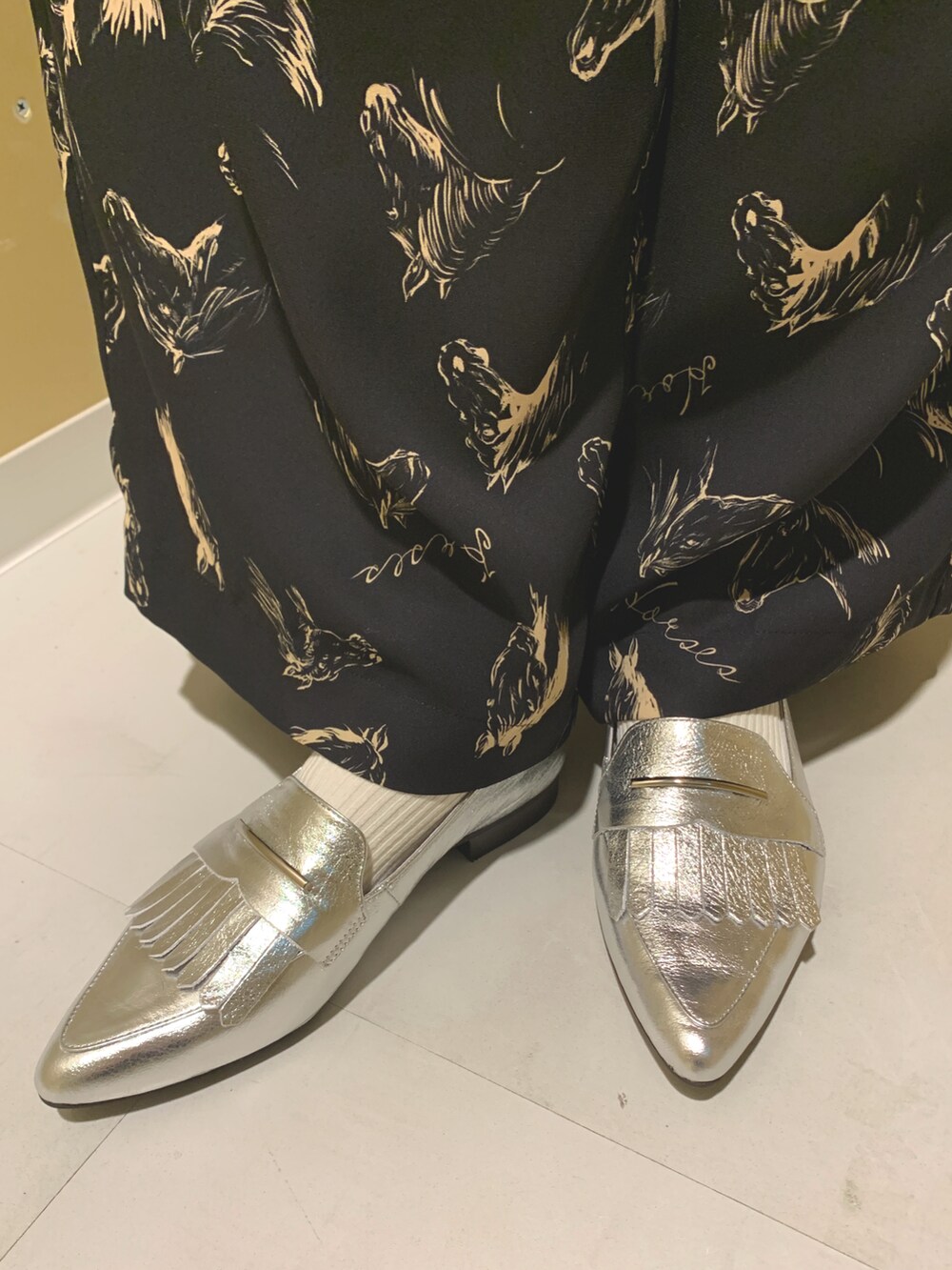 シルバー系のローファーを着用したレディースの冬コーディネートの2枚目の写真