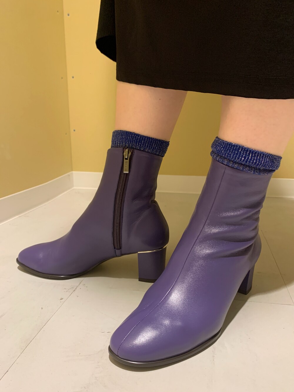 パープル系のブーツを着用したレディースの秋コーディネートの2枚目の写真