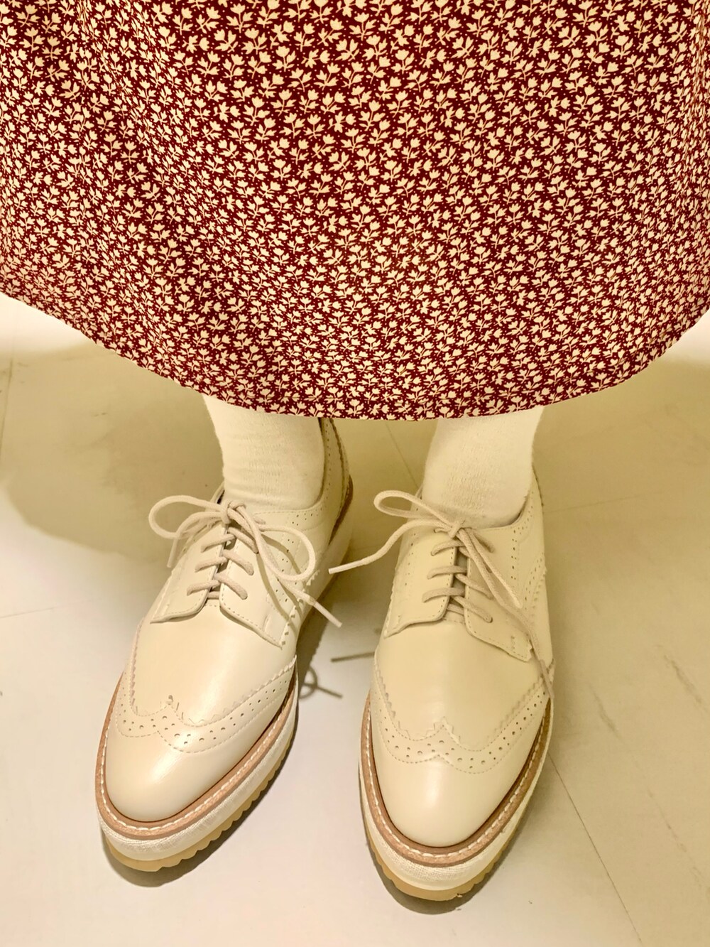 ホワイト系のパンプスを着用したレディースの春コーディネートの2枚目の写真