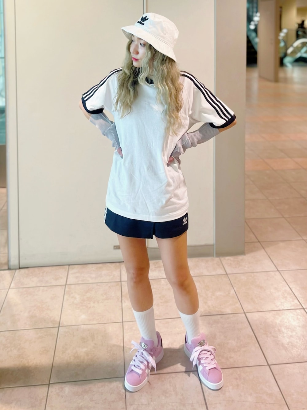 ホワイト系のTシャツ/カットソー、ブラック系のスカート、パープル系のスニーカーを着用したレディースの春コーディネートの3枚目の写真