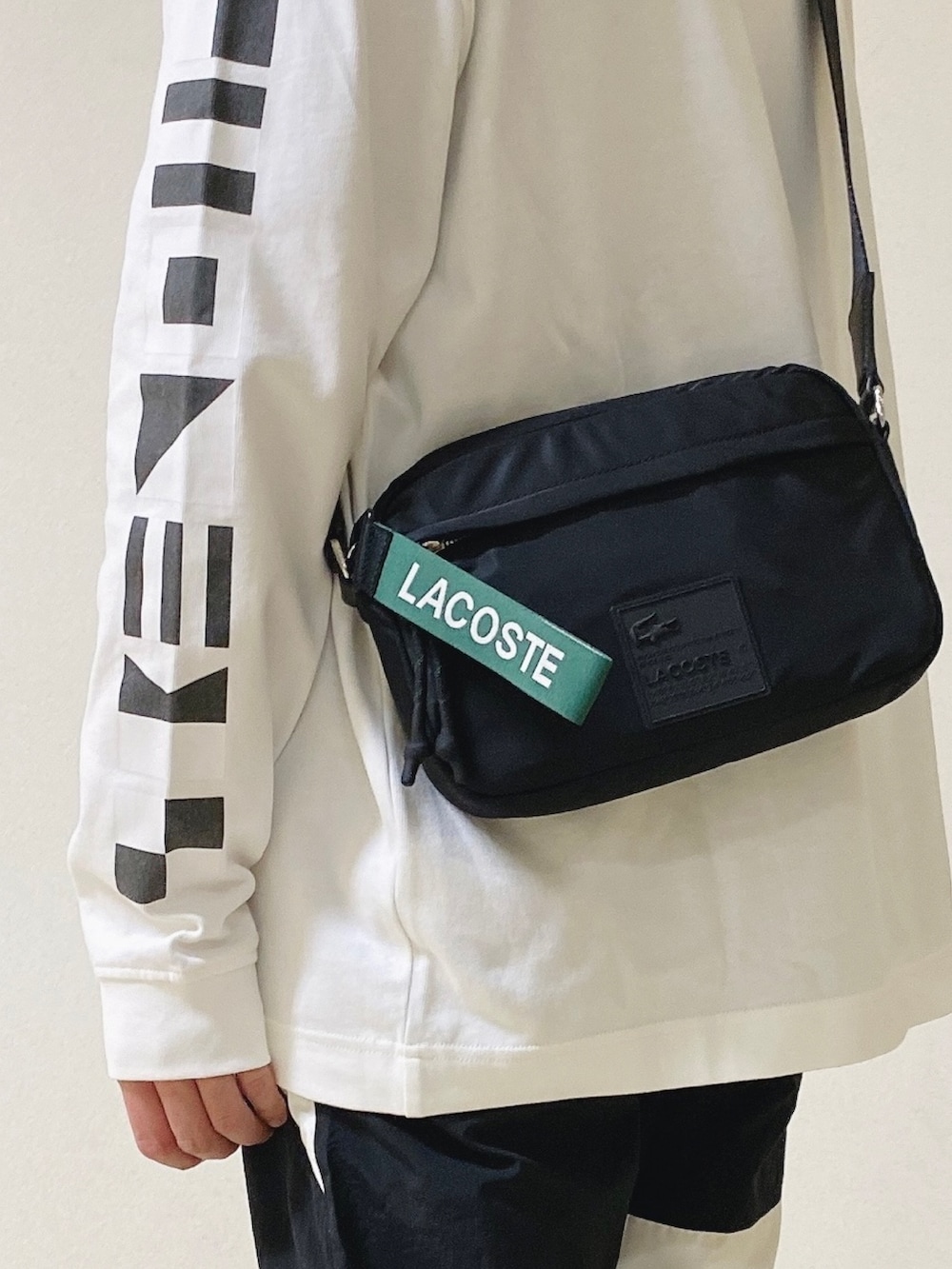 「ロンT、白ロンT、トラックパンツ、スニーカー、黒スニーカー、ショルダーバッグ、ラコステ」｜「LACOSTEのメンズ L003 0722 1（スニーカー、ブラック系）」を使った、maaashiiiiiiさん（メンズ・167cm）の春コーディネートの4枚目の写真