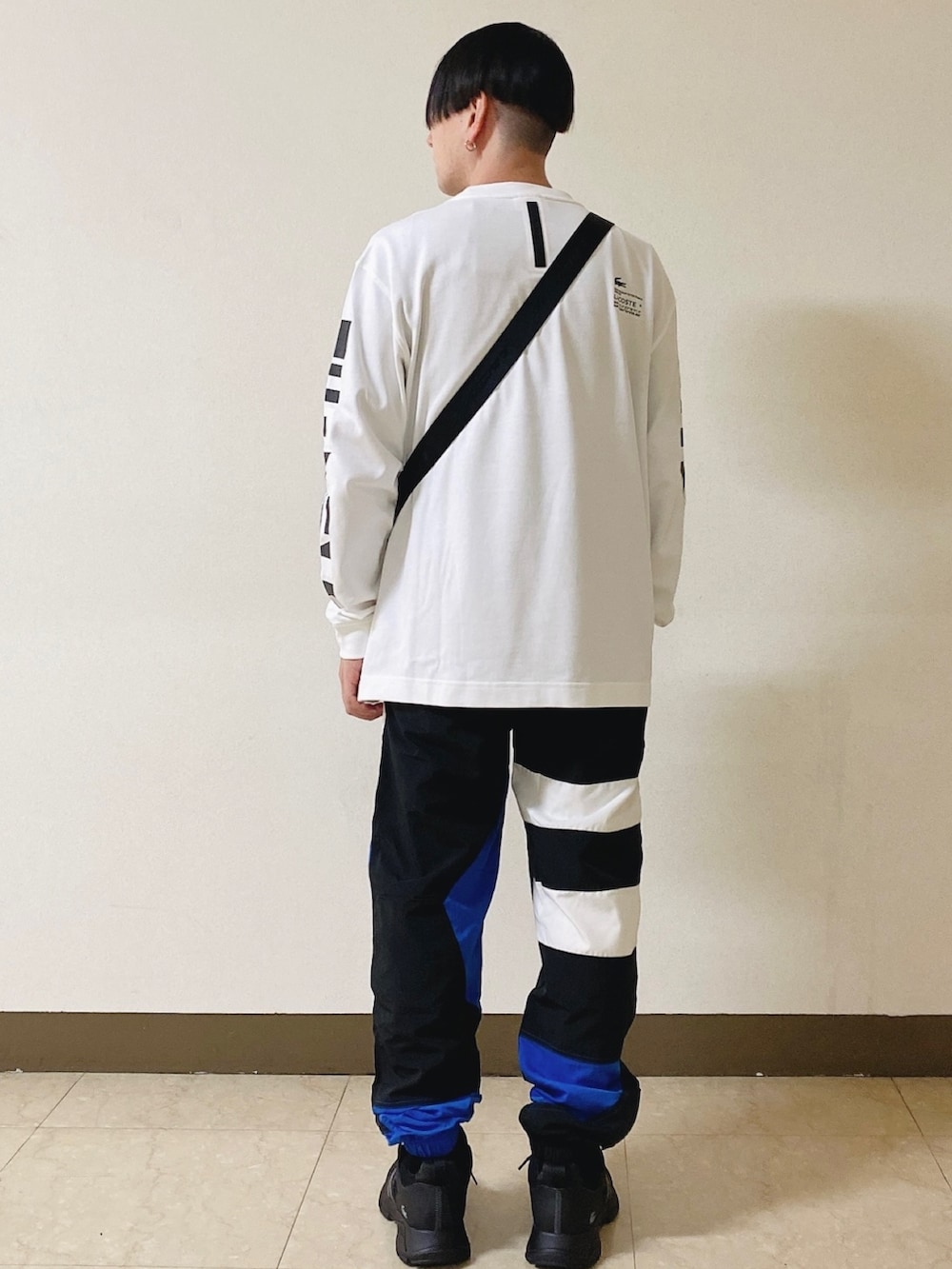 「ロンT、白ロンT、トラックパンツ、スニーカー、黒スニーカー、ショルダーバッグ、ラコステ」｜「LACOSTEのメンズ L003 0722 1（スニーカー、ブラック系）」を使った、maaashiiiiiiさん（メンズ・167cm）の春コーディネートの2枚目の写真