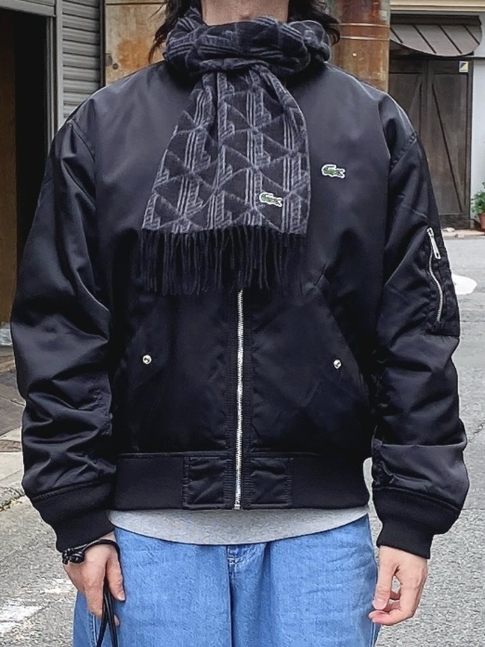 「ラコステ、LACOSTE、ボンバージャケット、MA-1、ワイドデニム、マフラー、スニーカー、巾着ポーチ」｜「LACOSTEのモノグラムジャカードマフラー（マフラー、ブラック系）」を使った、maaashiiiiiiさん（メンズ・167cm）の冬コーディネートの4枚目の写真