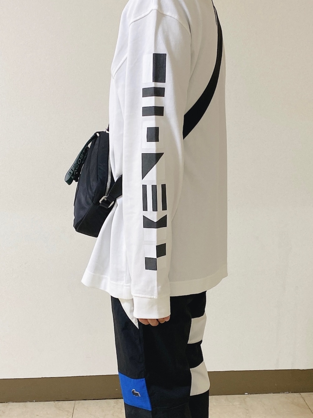 「ロンT、白ロンT、トラックパンツ、スニーカー、黒スニーカー、ショルダーバッグ、ラコステ」｜「LACOSTEのメンズ L003 0722 1（スニーカー、ブラック系）」を使った、maaashiiiiiiさん（メンズ・167cm）の春コーディネートの3枚目の写真