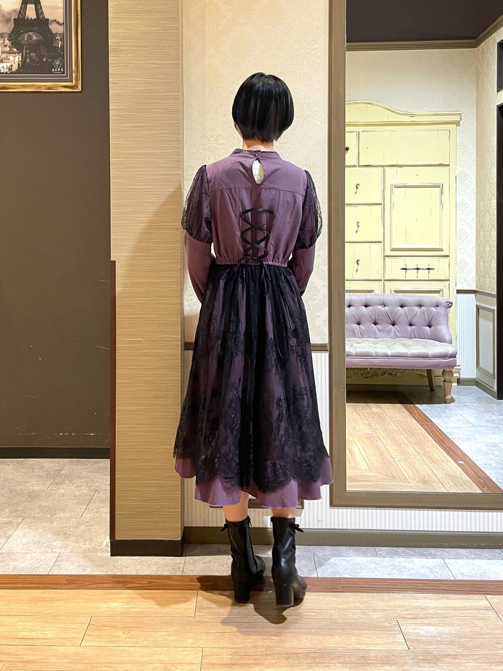 ブラック系のテーラードジャケット、パープル系のワンピース、ブラック系のブーツを着用したレディースの秋コーディネートの6枚目の写真