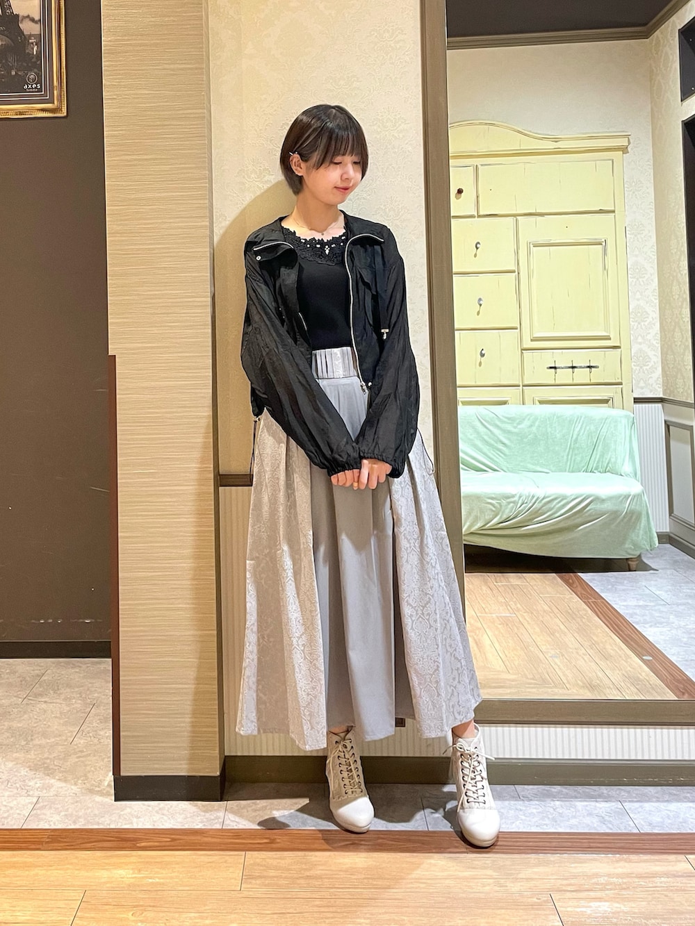 ブラック系のタンクトップ、ブラック系のブルゾン、ホワイト系のショルダーバッグを着用したレディースの秋コーディネートの2枚目の写真