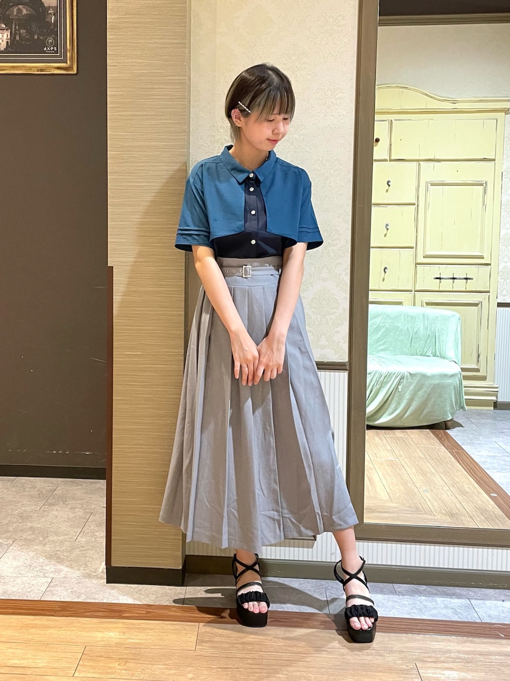 ホワイト系のタンクトップ、ブラック系のショルダーバッグ、グレー系のスカートを着用したレディースの夏コーディネートの5枚目の写真