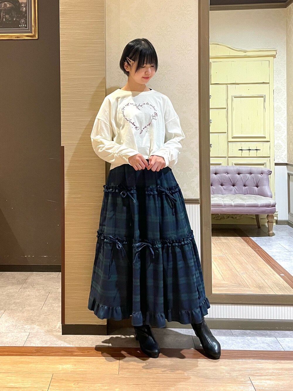 ブラック系のショルダーバッグ、ブラック系のブーツ、グリーン系のスカートを着用したレディースの秋コーディネートの8枚目の写真