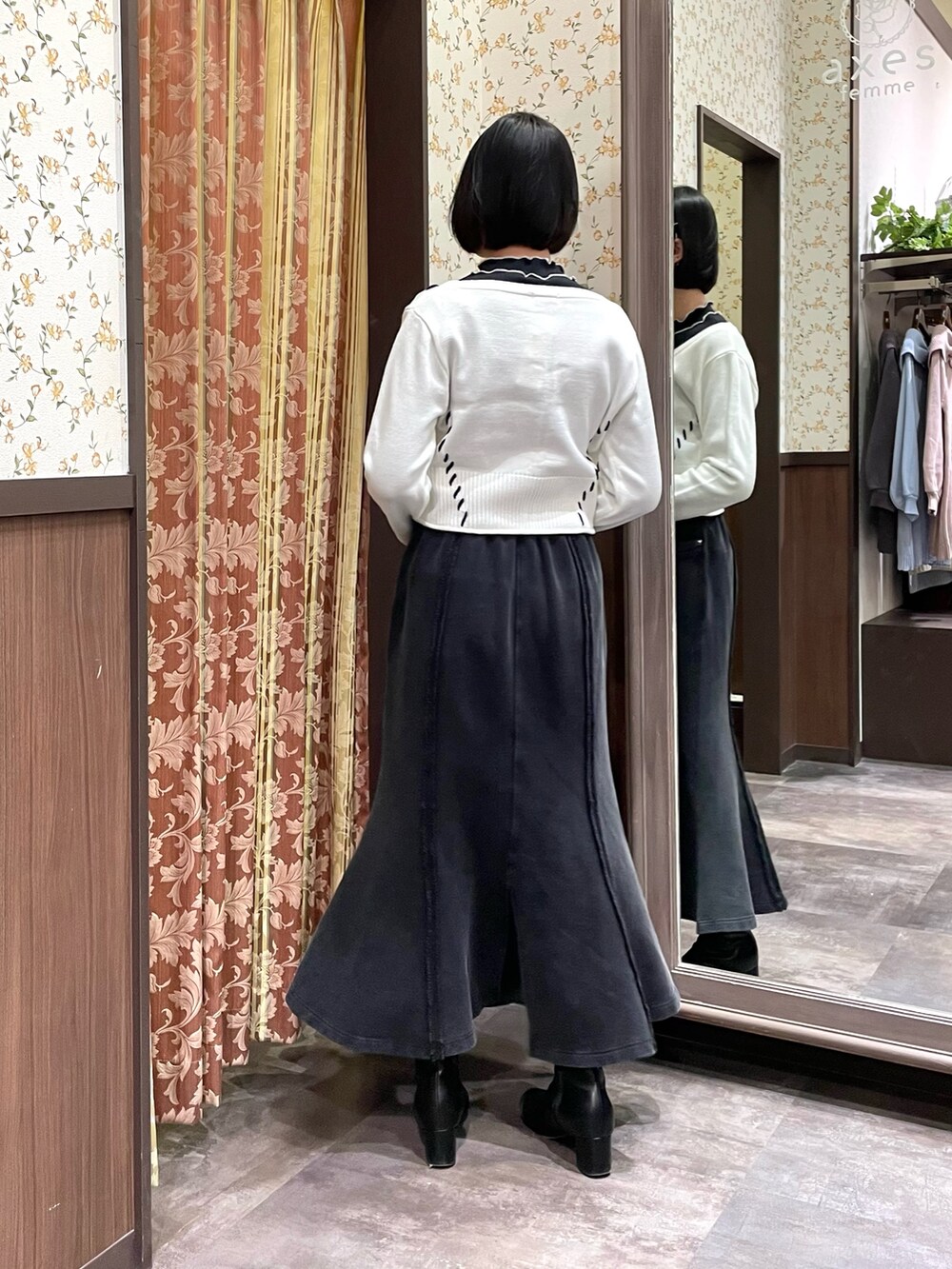 ブラック系のTシャツ/カットソー、ホワイト系のカーディガン/ボレロ、ブラック系のスカートを着用したレディースの冬コーディネートの3枚目の写真