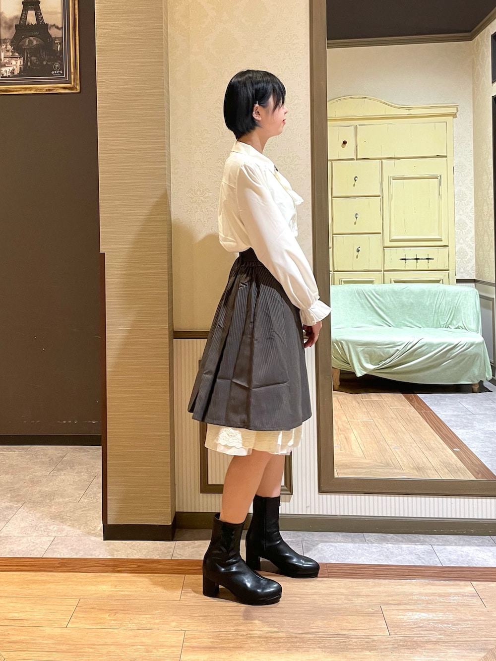 ブラック系のショルダーバッグ、ブラック系のブーツ、グレー系のカーディガン/ボレロを着用したレディースの秋コーディネートの6枚目の写真