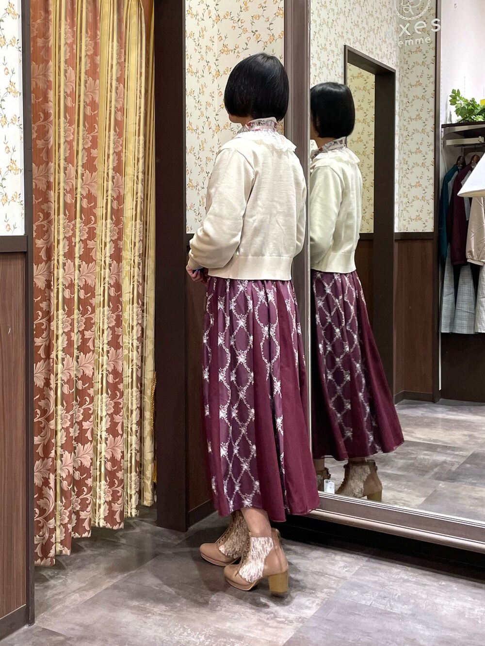 ホワイト系のカーディガン/ボレロ、グリーン系のシャツ/ブラウス、レッド系のスカートを着用したレディースの冬コーディネートの3枚目の写真