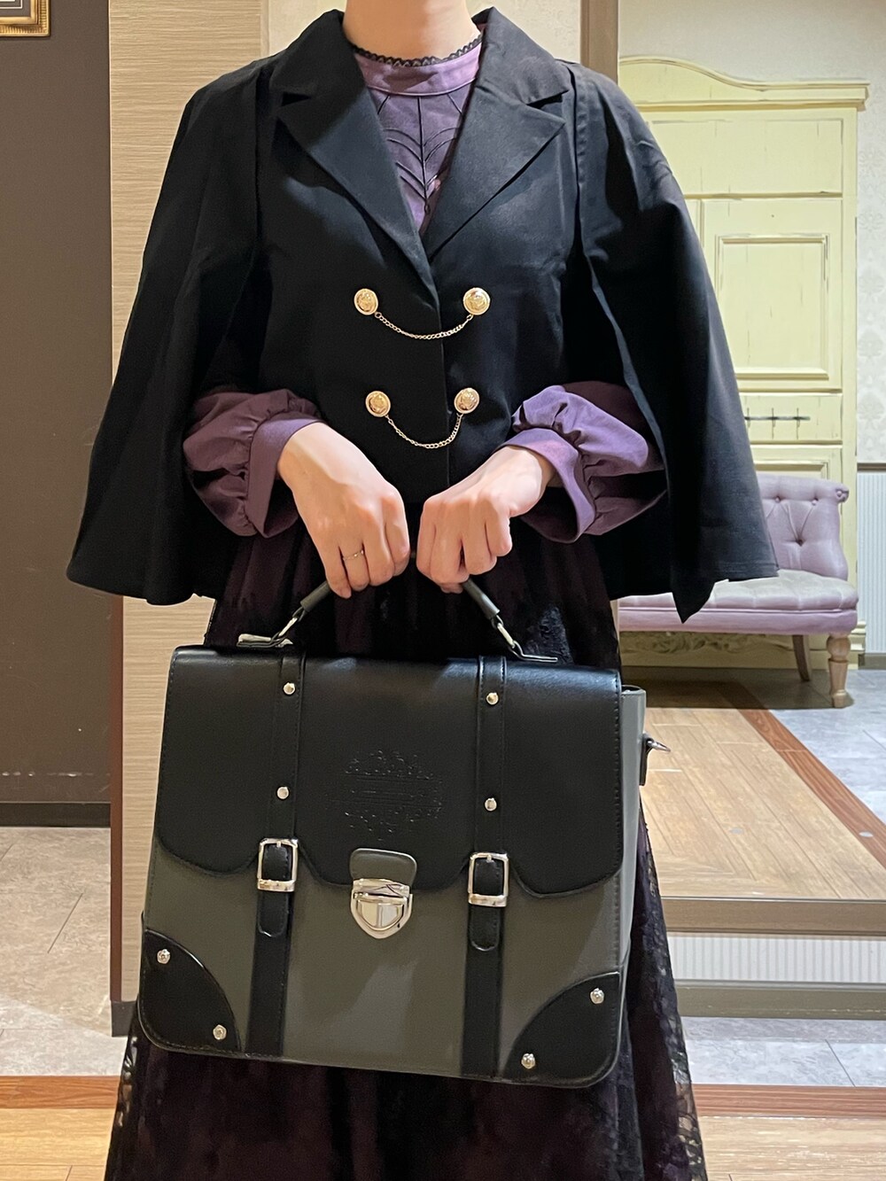 ブラック系のテーラードジャケット、パープル系のワンピース、ブラック系のブーツを着用したレディースの秋コーディネートの3枚目の写真