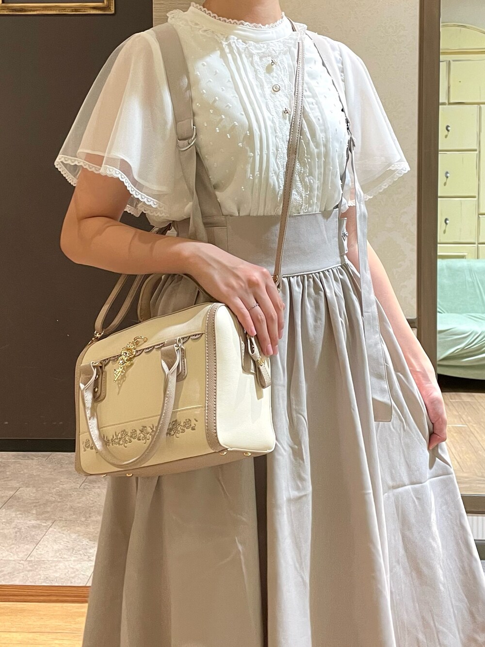 ベージュ系のスカート、グレー系のスニーカー、ホワイト系のシャツ/ブラウスを着用したレディースの夏コーディネートの3枚目の写真