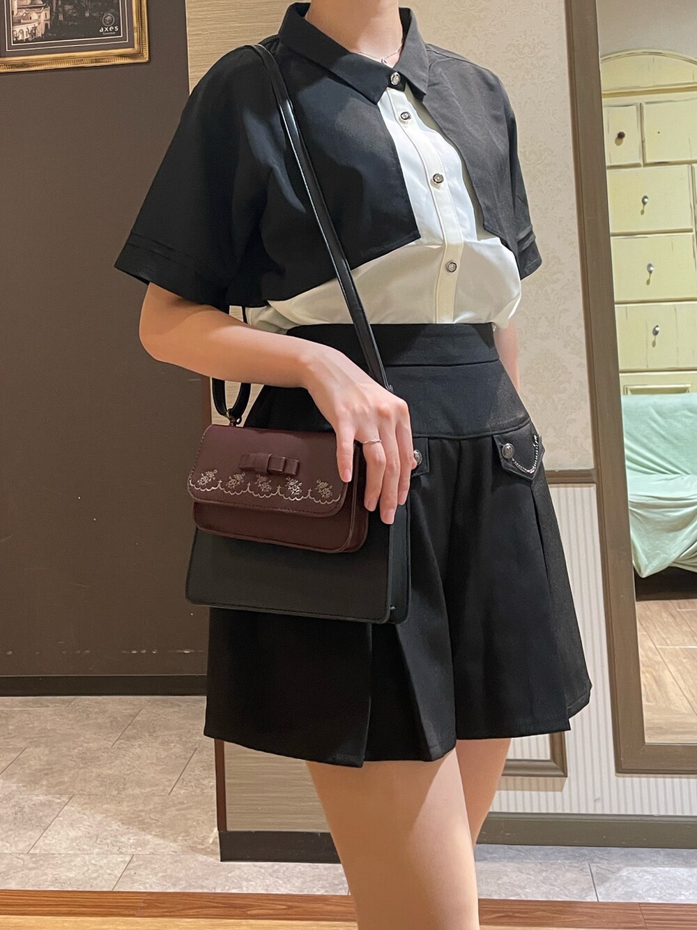 ブラック系のシャツ/ブラウス、ブルー系のその他パンツ、ブラック系のショルダーバッグを着用したレディースの秋コーディネートの4枚目の写真