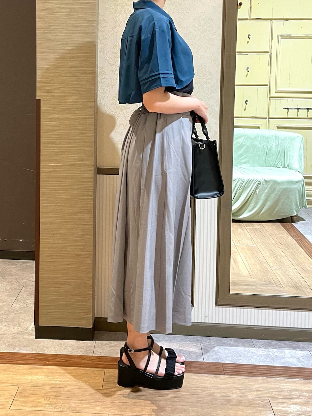 ホワイト系のタンクトップ、ブラック系のショルダーバッグ、グレー系のスカートを着用したレディースの夏コーディネートの3枚目の写真
