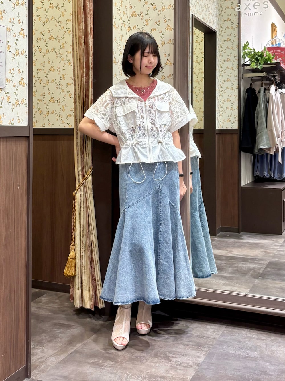 ホワイト系のカーディガン/ボレロ、レッド系のタンクトップ、ブルー系のデニムスカートを着用したレディースの春コーディネートの2枚目の写真