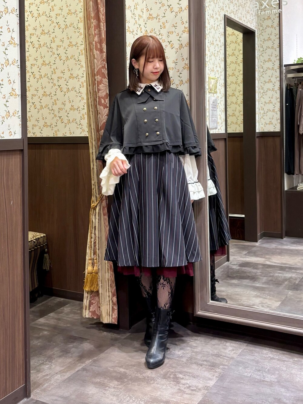 ブルー系のスカート、ブラック系のベスト、ホワイト系のシャツ/ブラウスを着用したレディースの秋コーディネートの5枚目の写真