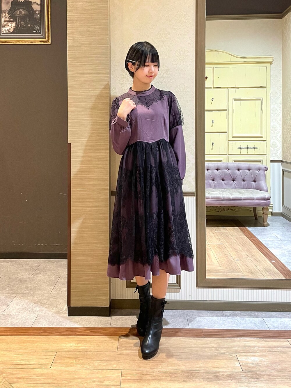 ブラック系のテーラードジャケット、パープル系のワンピース、ブラック系のブーツを着用したレディースの秋コーディネートの4枚目の写真