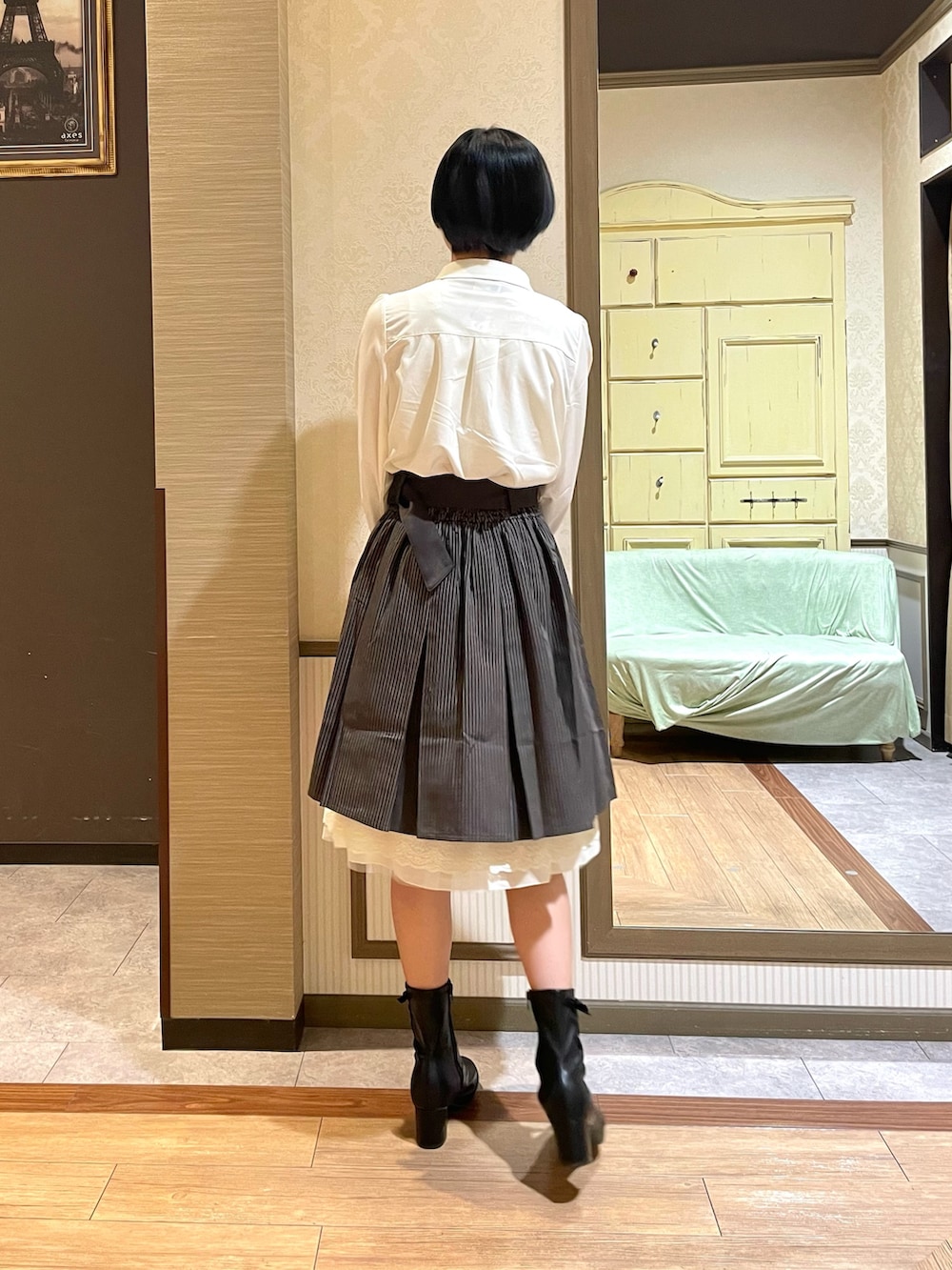 ブラック系のショルダーバッグ、ブラック系のブーツ、グレー系のカーディガン/ボレロを着用したレディースの秋コーディネートの7枚目の写真