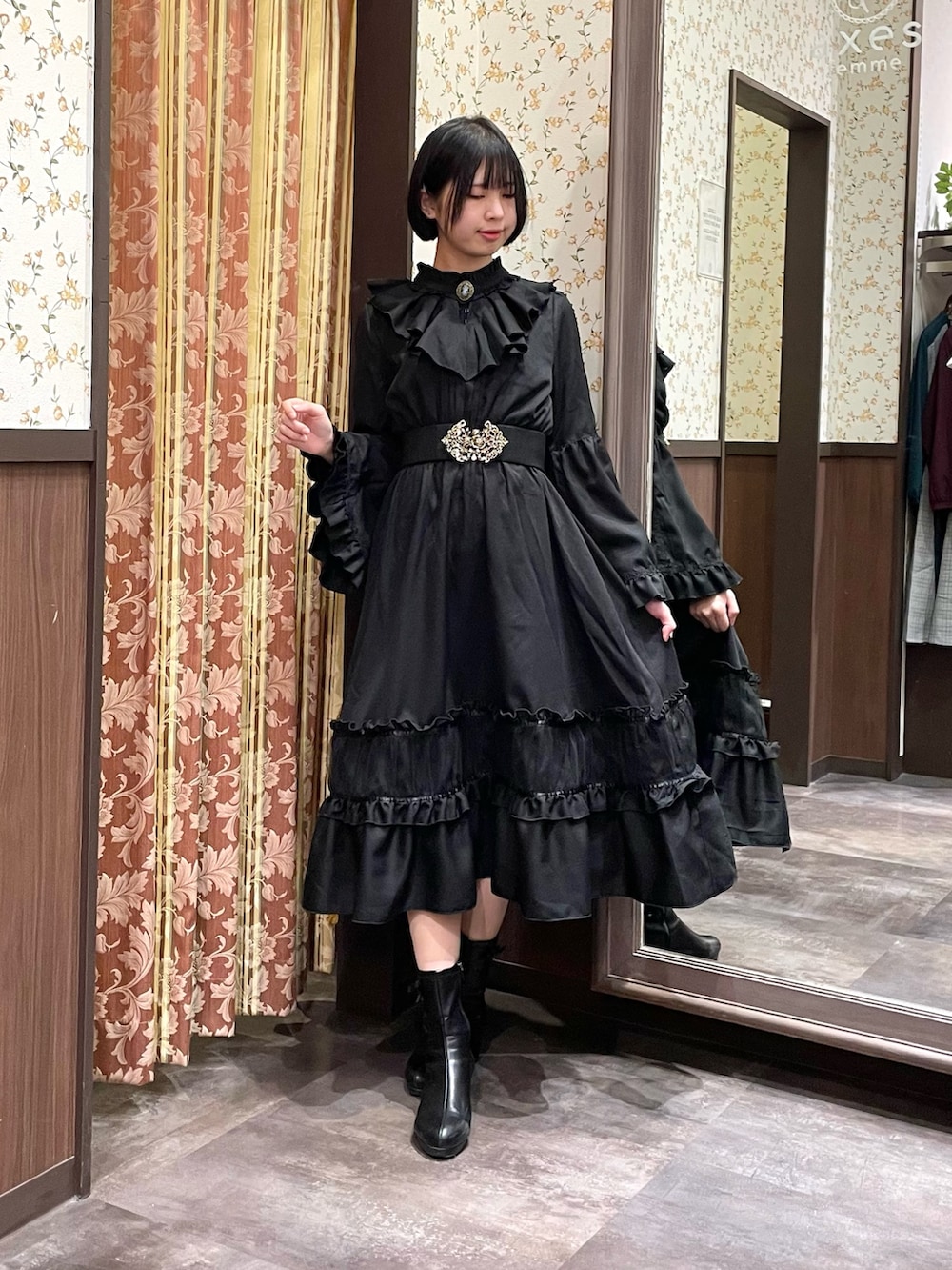 ブラック系のワンピース、ブラック系のブーツ、レッド系のショルダーバッグを着用したレディースの冬コーディネートの2枚目の写真